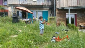 Un jeune habitant jouant dans le jardin commun